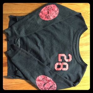 This is a dark grey and pink sweatshirt by Delia’s